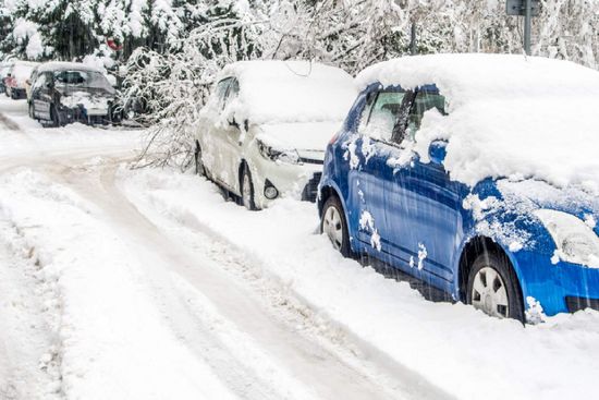 Lumen peittämiä autoja parkissa